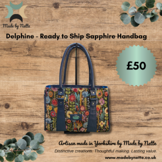 Colourful floral tapestry Sapphire handbag with navy faux leather accents, displayed with Made by Nette branding.