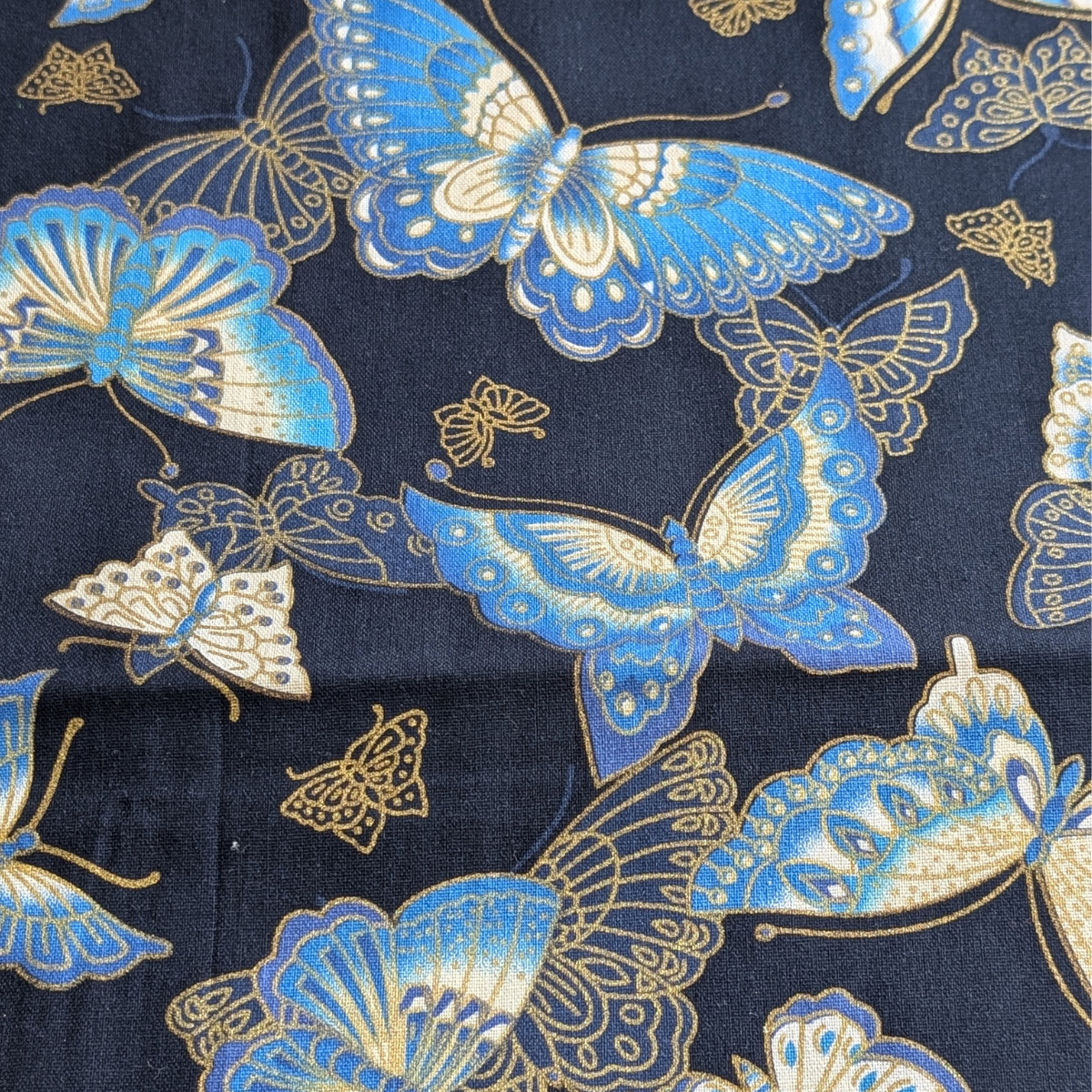 A patterned cotton fabric combining shades of blue with cream and gold detailing for an elegant, decorative finish.