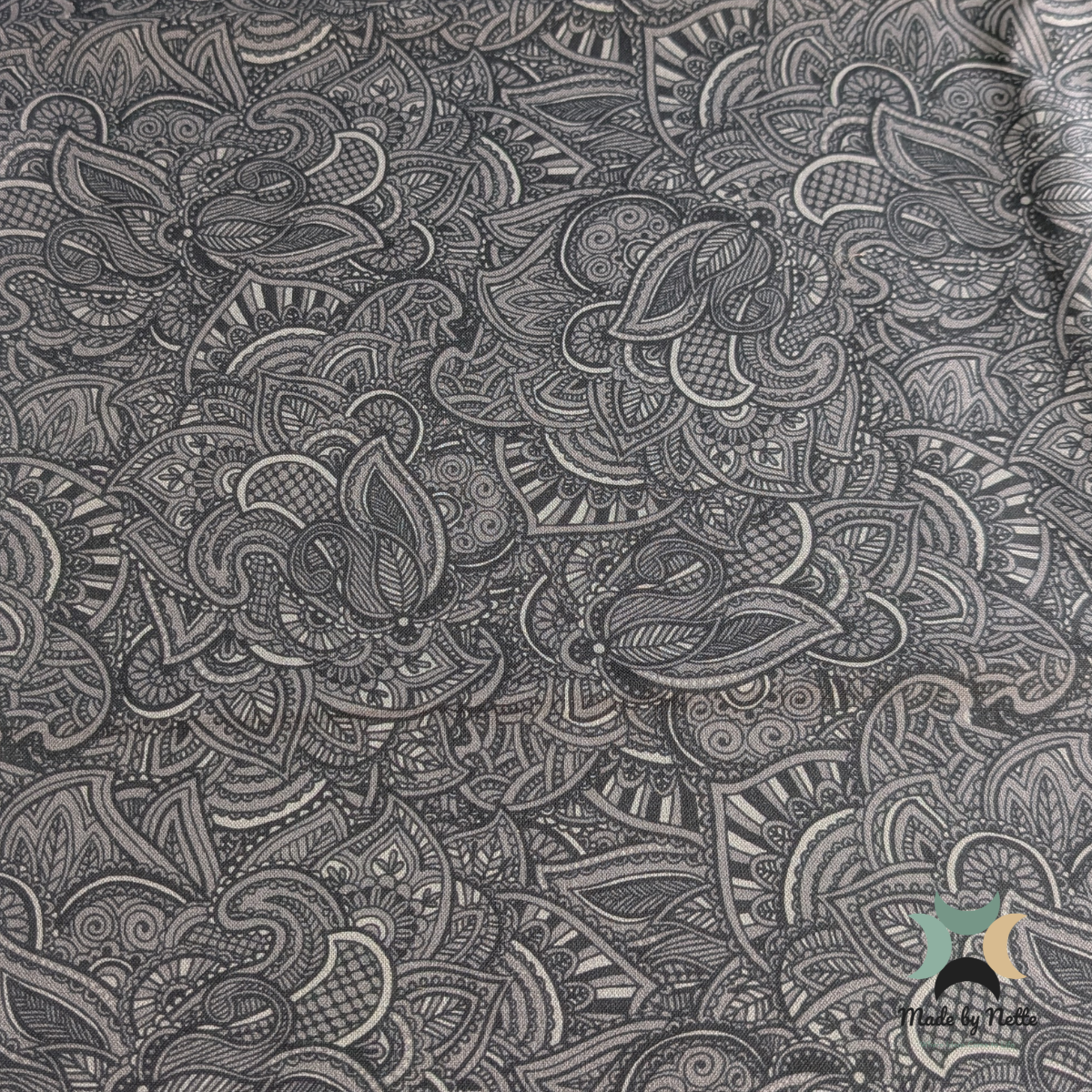 A patterned cotton fabric featuring a grey paisley design for a classic, decorative finish.