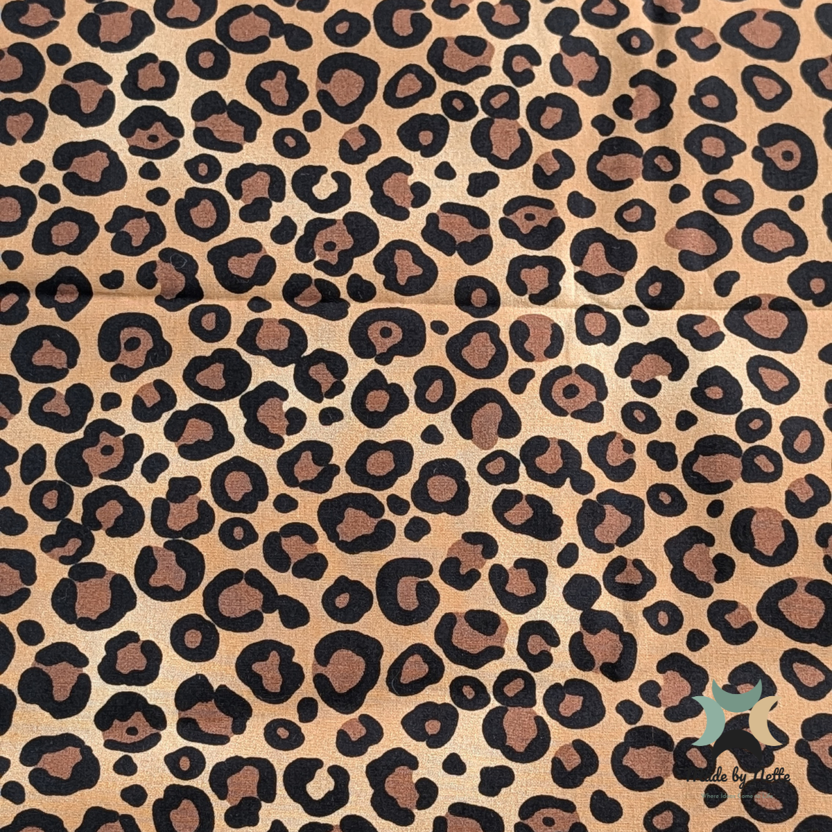A patterned cotton fabric featuring a leopard print for a bold, eye-catching finish.